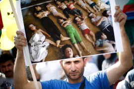 ATTENTION EDITORS - VISUALS COVERAGE OF SCENES OF DEATH AND INJURY A man holds an image during a demonstration in front of the Syrian embassy in Sofia August 23, 2013. Syrians living in Bulgaria gathered on Friday to protest against a suspected chemical weapons attack in Damascus. REUTERS/Stoyan Nenov (BULGARIA - Tags: CIVIL UNREST POLITICS)