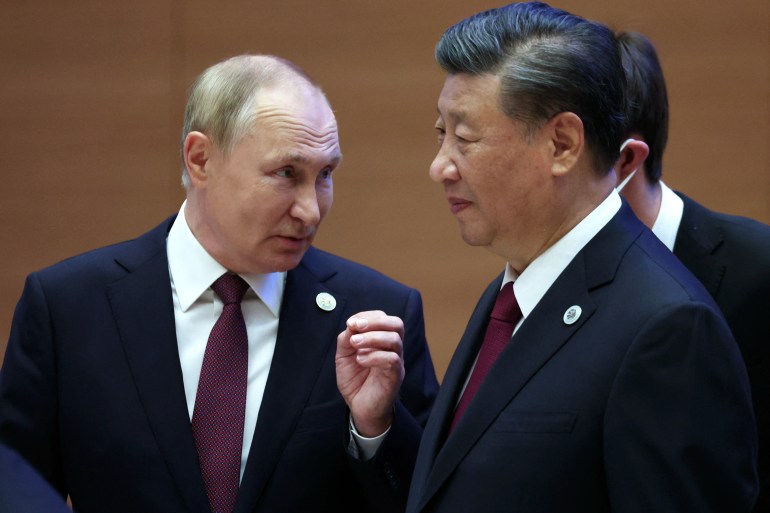 Russian President Vladimir Putin speaks to China's President Xi Jinping during the Shanghai Cooperation Organisation (SCO) leaders' summit in Samarkand on September 16, 2022. (Photo by Sergei BOBYLYOV / SPUTNIK / AFP)