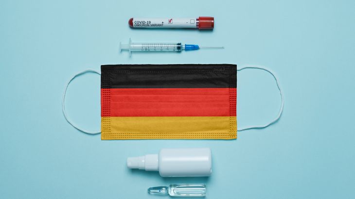 Blood tube for test detection of virus Covid-19 Omicron Variant with positive result, medicine mask with Germany flag superimposed and vaccine. New Variant of the Covid-19 Omicron