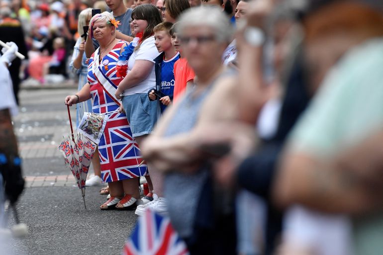 People watch the Twelfth of July Orange Order celebrations which marks the anniversary of Protestant King William's victory over the Catholic King James at the Battle of the Boyne in 1690, in the city centre of Belfast, Northern Ireland July 12, 2022. REUTERS/Clodagh Kilcoyne