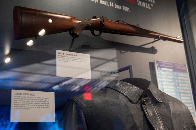 A Ruger M77 bolt action rifle brandished by Iraqi dictator Saddam Hussein is displayed along with the Saddam's leather jacket when he was captured by American forces is on display at the Central Intelligence Agency headquarters building's refurbished museum in Langley, Va., on Saturday, Sept. 24, 2022. (AP Photo/Kevin Wolf)