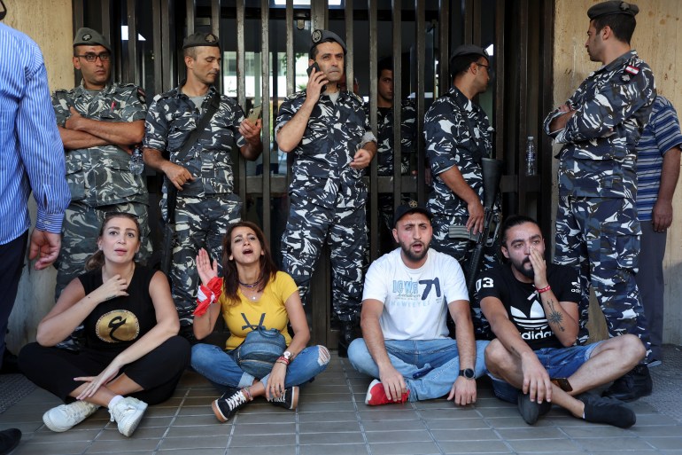 Protestors shout slogans as they sit outside an LGB Bank branch which was held up by a depositor seeking access to his own savings, according to a bank employee, in Ramlet al-Bayda area in Beirut, Lebanon September 16, 2022. REUTERS/Mohamed Azakir