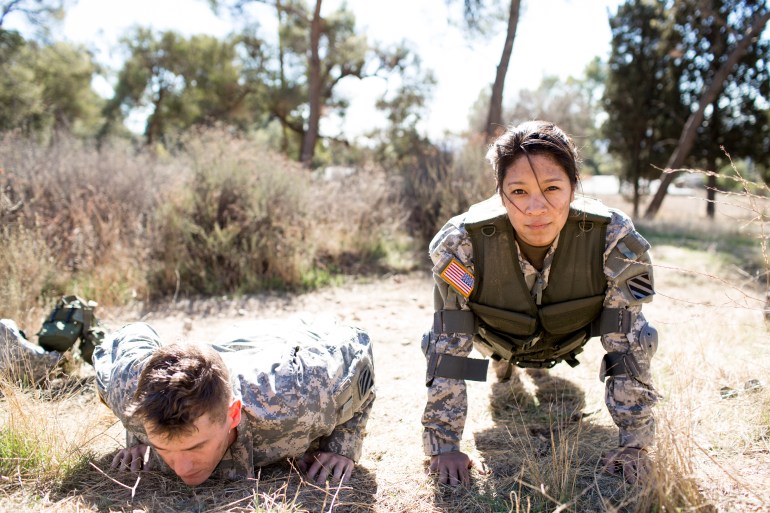 Army woman and man doing pushups in field US