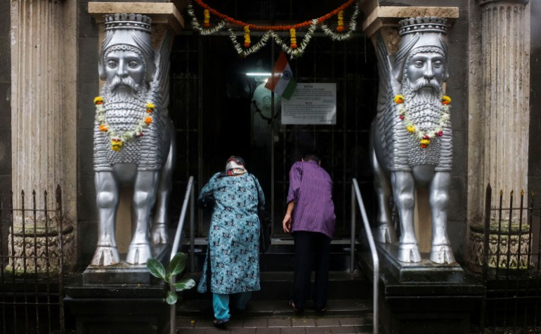 A Parsi couple bows before entering a fire temple on the occasion of the Persian New Year, in Mumbai