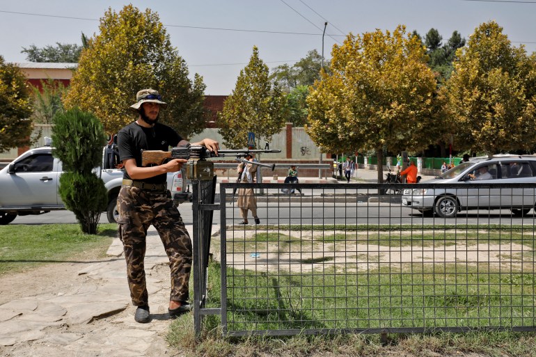 A Taliban fighter stands guard after a blast in front of the Russian embassy in Kabul