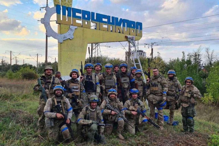 Ukrainian service members pose for in the recently liberated settlement of Vasylenkove in Kharkiv region