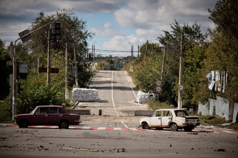 Damaged cars are seen in the recently liberated town of Kupiansk