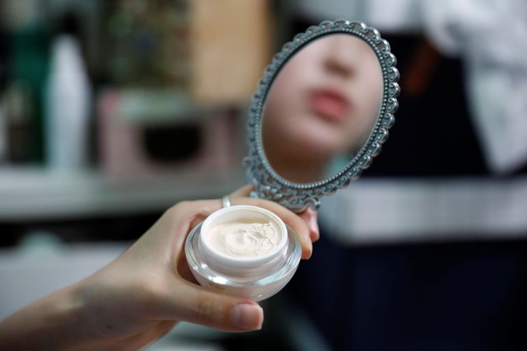 Kang Na-ra, a North Korean defector who is now a beauty YouTuber, puts on her makeup with North Korean cosmetic products, in Seoul