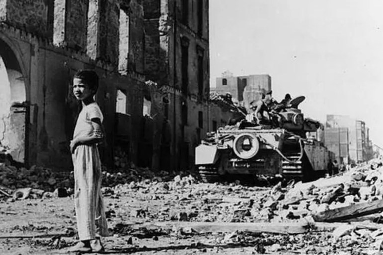 طفل مصري بجوار دبابة بريطانية وسط الدمار الذي حل بمدينة بورسعيد جراء العدوان الثلاثي عام 1956