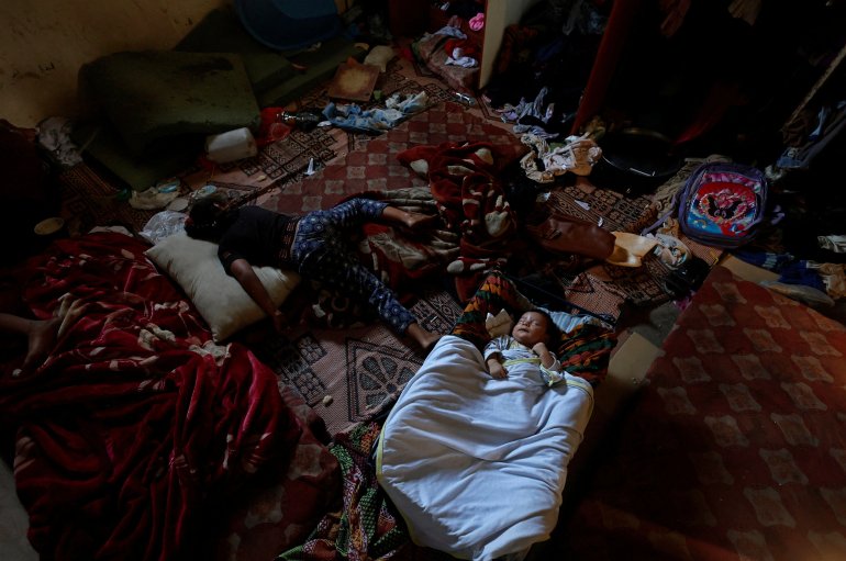 Yosra Kuhail and two-month-old Ahmed Kuhail sleep in their family home. The Kuhail family’s house was built on the graves of two unknown people whose remains are now buried under the foundations. [Mohammed Salem/Reuters
