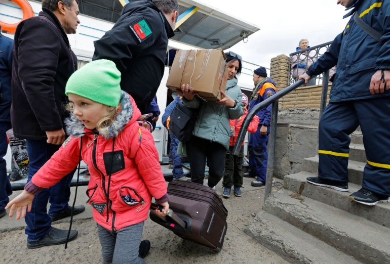 Civilians evacuated from Kherson disembark a ferry as they arrive in the town of Oleshky. [Alexander Ermochenko/Reuters]