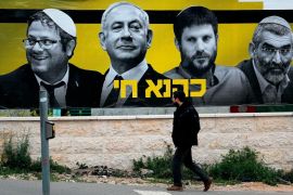 An Israeli man walks past an electoral billboard bearing portraits of Prime Minister Benjamin Netanyahu flanked by extreme right politicians Itamar Ben Gvir, Bezalel Smotrich and Michael Ben Ari, with a caption in Hebrew reading "Kahana Lives" in a reference to a banned ultranationalist party in the 1994, in Jerusalem, on March 29, 2019. Israeli general elections will be held on April 9, 2019. THOMAS COEX / AFP