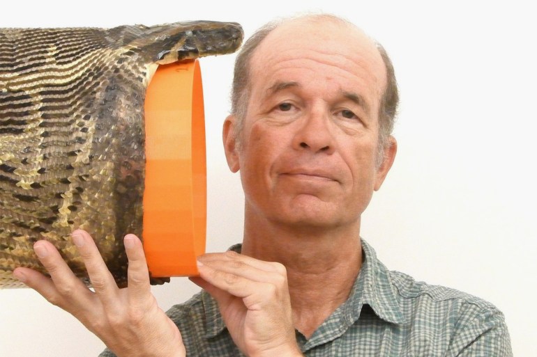 UC professor Bruce Jayne demonstrates how wide a Burmese python can open its mouth to swallow prey. Jayne studied wild specimens captured and euthanized in Florida. © Photo Photo/Provided