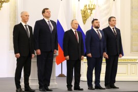 بوتين يتوسط قادة المناطق الأربع في أثناء احتفال بضمها إلى روسيا (الأناضول)