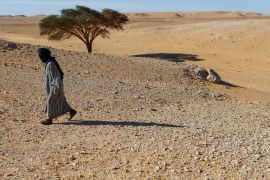 A Sahrawi man walks through the desert in the Smara refugee camp in Tindouf