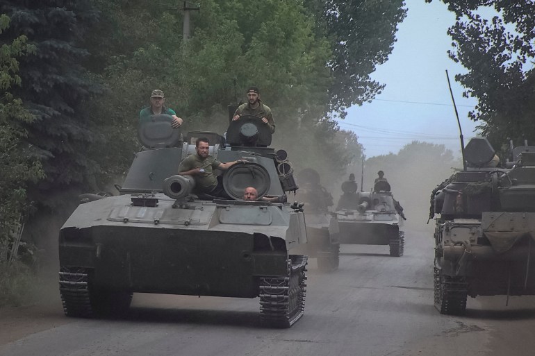 Ukrainian servicemen ride self-propelled howitzers not far from front line in Donetsk region