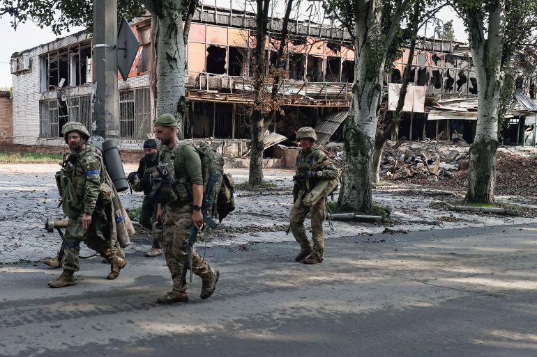 Ukrainian soldiers walk in Bakhmut