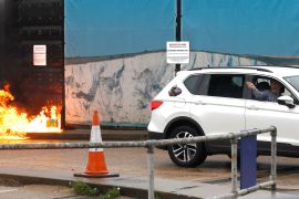 A man throws an object out of a car window next to the Border Force centre after a firebomb attack in Dover