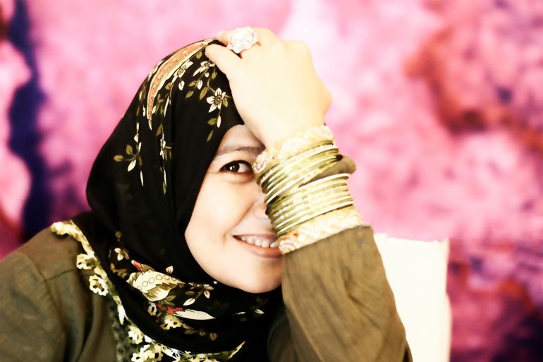 A beautiful muslim woman close up shot smiling in front of pink background gettyimages-1174090755