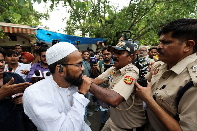 Police officials try to detain a supporter of All India Students' Association (AISA) during a protest against what they say attacks on Muslims following clashes last week triggered by remarks made by ruling Bharatiya Janata Party (BJP) figures on Prophet Mohammad, at Jantar Mantar, in New Delhi, India, June 13, 2022. REUTERS/Anushree Fadnavis