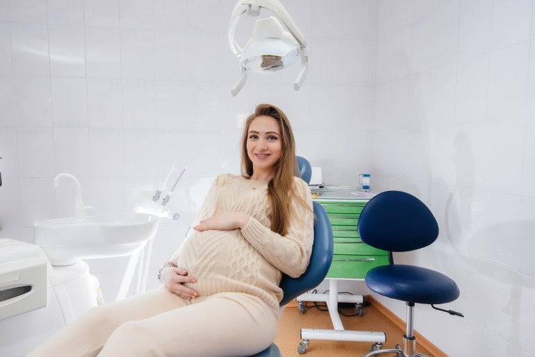 A professional dentist treats and examines the oral cavity of a pregnant girl in a modern dental office. Dentistry; Shutterstock ID 2047405478; purchase_order: ajnet; job: ; client: ; other: