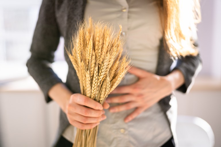 Celiac Disease And Gluten Intolerance. Women Holding Spikelet Of Wheat