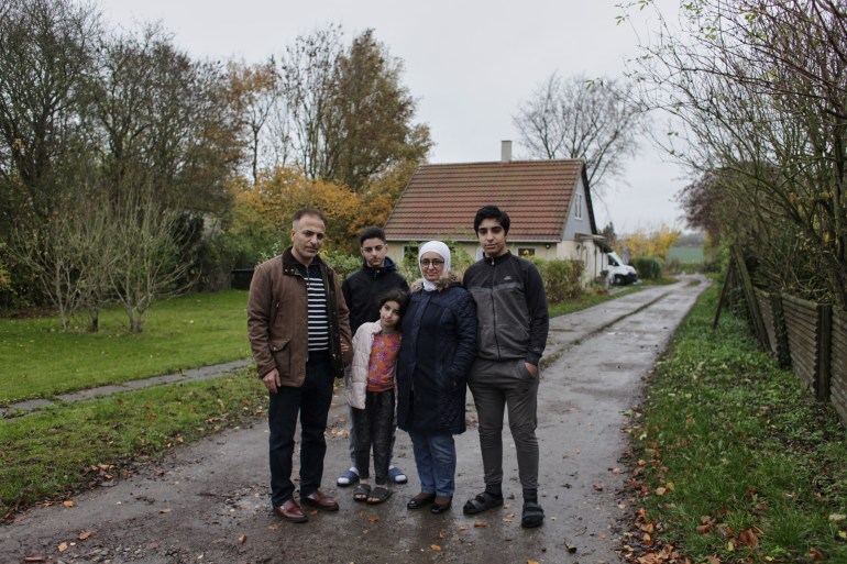 Syrian refugee Bilal Alkale (L) poses with wife Sawsan Doungham (2nd R) daughter Rawan (C) and sons Majed (2ndL) and Said (R) in front of their rented home in Lundby in the municipality of Vordingborg, Denmark on November 17, 2021. - Their lives are paused in a never-ending wait: Bilal Alkale and his family are among the hundreds of Syrian refugees in Denmark whose temporary residency permits have been revoked -- but they can't be deported and now they have no rights. (Photo by Thibault Savary / AFP)