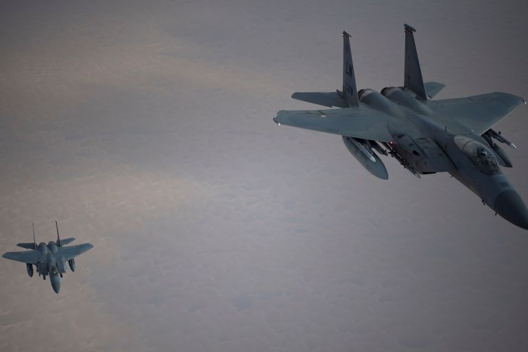 Royal Saudi Air Force F-15C Eagles fly in formation with a U.S. Air Force F-15C in an undisclosed location