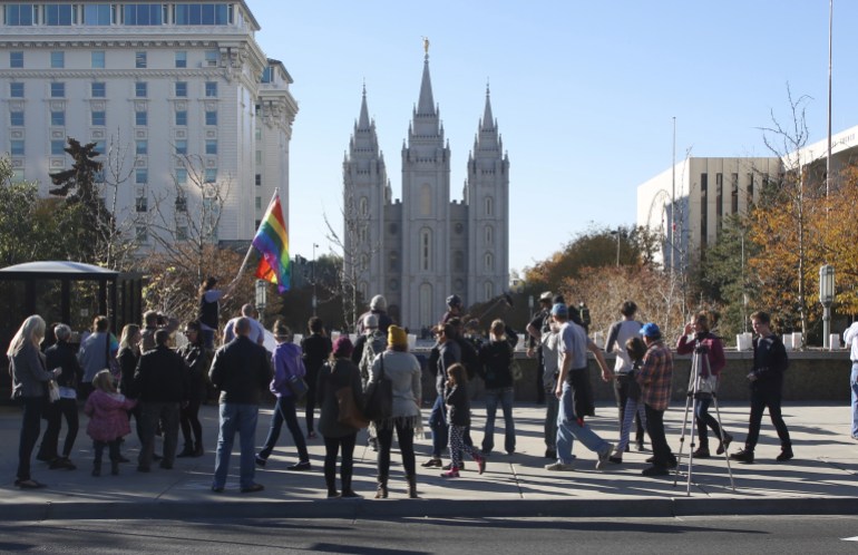 Members of The Church of Jesus Christ of Latter-day Saints and their supporters walk near the Salt Lake Temple after mailing their membership resignation to the church in Salt Lake City, Utah