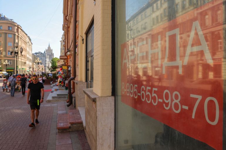 A pedestrian walks past the windows of business premises put out for rent in Moscow
