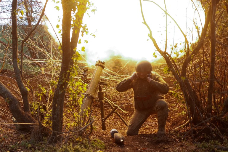 Ukrainian serviceman fires with a mortar toward Russian positions in a frontline in Mykolaiv region