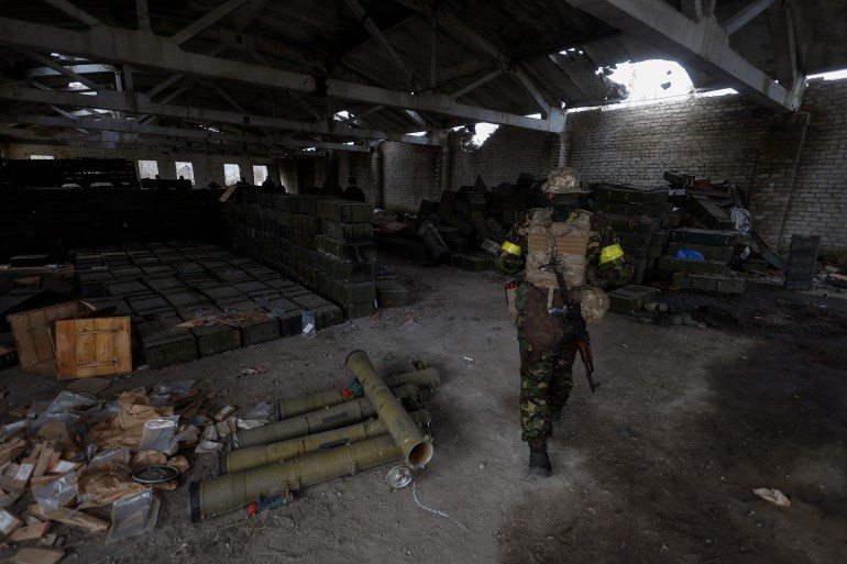 Ukrainian soldier walks past captured Russian ammunition in the village of Blahodatne in Kherson region