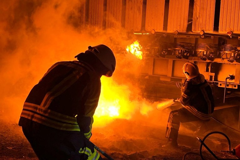 Firefighters work to put out a fire at energy infrastructure facilities, damaged by a Russian missile strike in Kyiv region