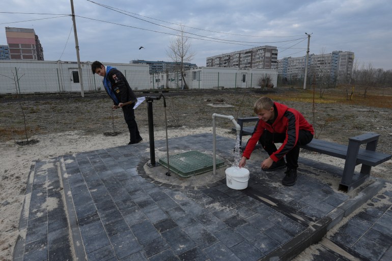 Local residents fill up a bucket with water in Kamianske
