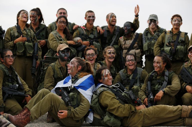 Israeli soldiers of the Caracal battalion gather to have their photograph taken during a 20-kilometre march in Israel's Negev desert, near Kibbutz Sde Boker, marking the end of their training, May 29, 2014. The "Caracal" battalion, two-thirds of whose members are women, was established in 2004 with the purpose of incorporating female soldiers in combat units. The main mission of Caracal is routine patrols on Israel's border with Egypt to intercept infiltrators and smuggling from the Sinai desert. REUTERS/Amir Cohen (ISRAEL - Tags: MILITARY)