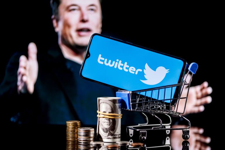 Kazan, Russia - Apr 26, 2022: Logo of social network Twitter on smartphone screen in shopping cart with money and photo Elon Musk in background. Elon Musk reaches agreement to acquire Twitter.