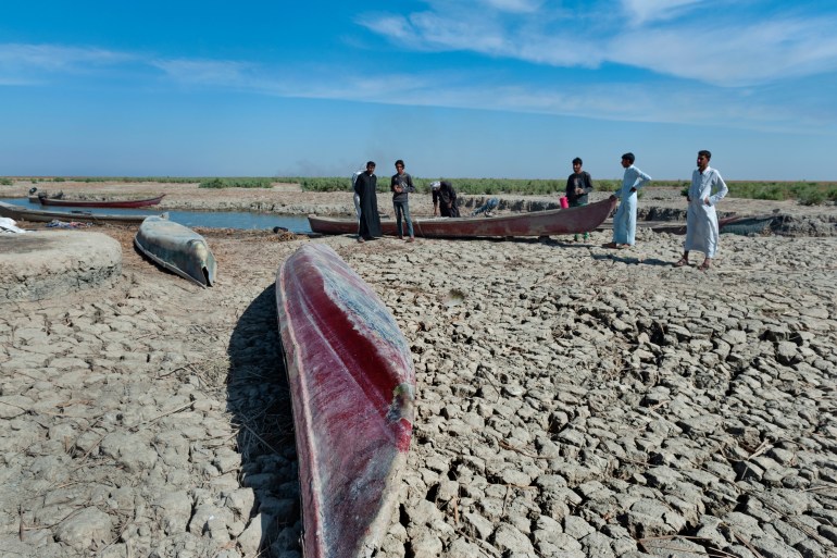 Al Chibayish, Iraq. November 1st, 2018 Boats on dried cracked earth during a drought in the Southern Marshes of Iraq. Climate change and political instability causing a crisis for local fishermen and