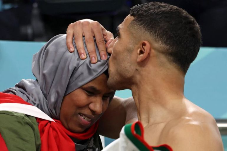 نجم المنتخب المغربي أشرف حكيمي يقبل رأس والدته عقب الفوز على منتخب إسبانيا (الفرنسية)