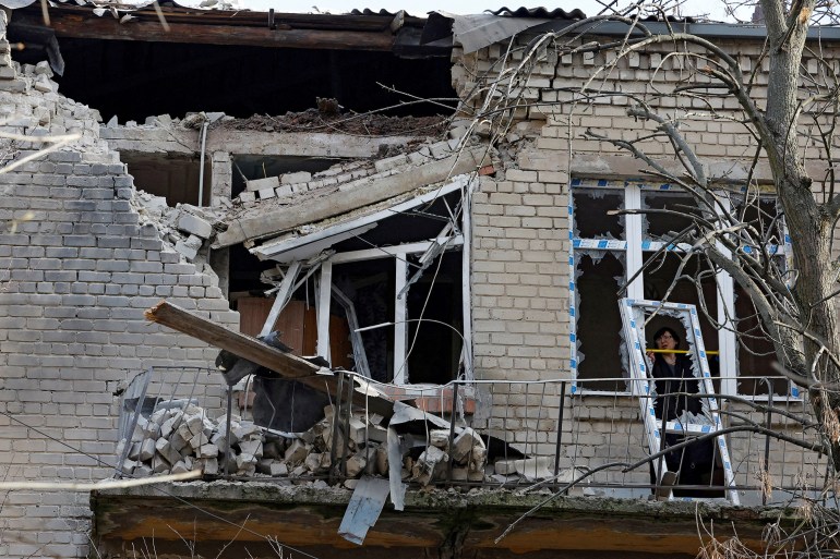 A woman measures size of a broken hospital window following recent shelling in the course of Russia-Ukraine conflict in Donetsk, Russian-controlled Ukraine, December 15, 2022. REUTERS/Alexander Ermochenko