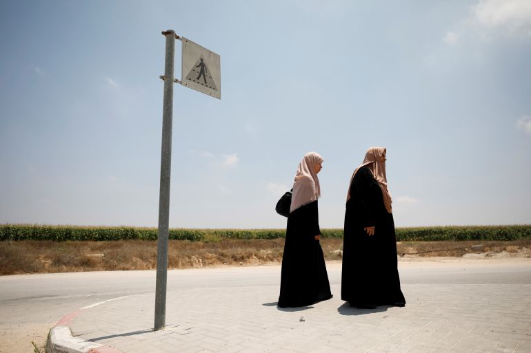 Palestinian women stand next to a road sign at the Israeli side of Erez crossing, on the border with Gaza June 23, 2019. REUTERS/Amir Cohen