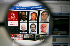 The homepage of the Interpol website is seen through a magnifying glass in this picture illustration taken in Berlin