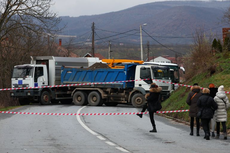 Local Serbs walk near a roadblock in Rudare