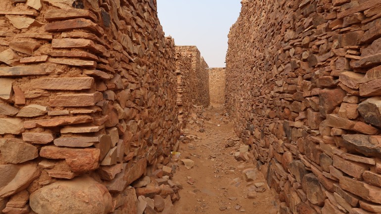 A pathway inside the ruins of Ouadane with high walls on both sides in the Mauritania desert; Shutterstock ID 1536850874; purchase_order: ajnet; job: ; client: ; other: