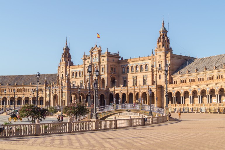 View of the Plaza de España (Spanish Square) in Seville on a sunny morning (Andalusia, Spain). Tourists visitin ...