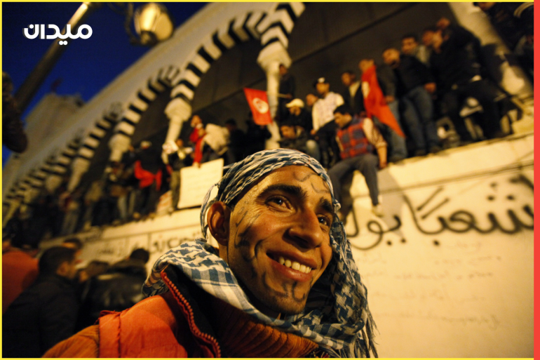 A protester from Tunisia's marginalised rural heartlands smiles as he prepares to spend his second night outside the Prime Minister's office in Tunis January 24, 2011. Protesters demonstrated in the capital on Sunday to demand that the revolution they started should now sweep the remnants of the fallen president's old guard from power. The arabic words on his face read, "Will power". REUTERS/Zohra Bensemra (TUNISIA - Tags: POLITICS CIVIL UNREST SOCIETY)
