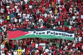 الجماهير ترفع علم فلسطين خلال مباراة بكأس العالم في قطر (رويترز)