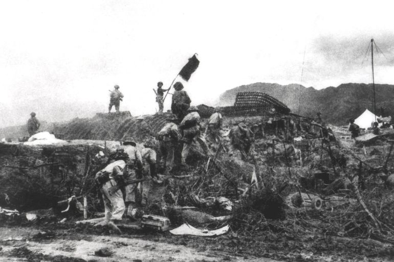 This picture taken 07 May 1954 shows a Vietnamese soldier waving a flag atop a French PC as others assault the area at the Dien Bien Phu battlefield. Vietnam will mark 13 March 2004 the 50th anniversary of the start of the siege of Dien Bien Phu, the epic battle that precipitated the collapse of French colonial rule in Indochina. The fighting began March 13, 1954, and 56 days later, 07 May, shell-shocked survivors of the French garnison hoisted the white flag to signal the end to one of the greatest battles of the 20th century. EDITOR'S NOTE: THE VAST MAJORITY OF VIETNAMESE PHOTOS OF THE BATTLE ARE RECONSTRUCTIONS DONE FOR THE PURPOSE OF PROPAGANDA. MOST OF THEM WERE TAKEN JUST HOURS AFTER THE ACTUAL EVENTS DEPICTED. AFP PHOTO/VNA/FILES (Photo by AFP / VNA FILES / AFP)