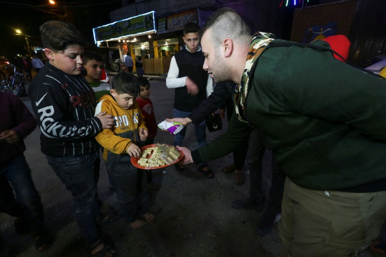 A man delivers food as Palestinians celebrate following Jerusalem’s shooting attack, in Khan Younis, in Southern Gaza Strip January 27, 2023. REUTERS/Ibraheem Abu Mustafa
