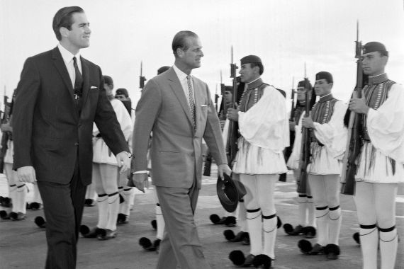 Greece King Constantine II FILE - In this March 25, 1965 file photo, King Constantine II of Greece, left, and Prince Philip of Britain review an honor guard of the Greek Royal Evzones Guard as the prince arrives at the Athens Airport for a brief visit as the guest of the Greek royal family. Constantine, the former and last king of Greece, has died his doctors announced late Tuesday Jan. 10, 2023. He was 82. (AP Photo/Aristotle Saris, File)