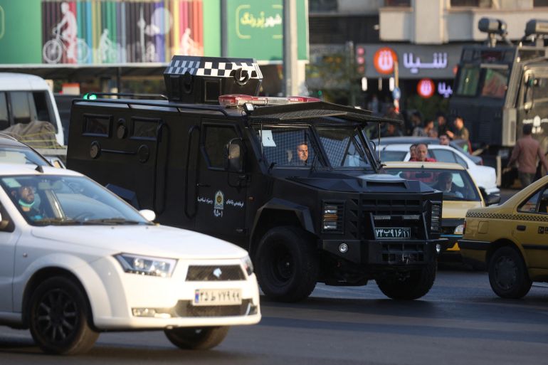 A riot police vehicle rides in a street in Tehran, Iran